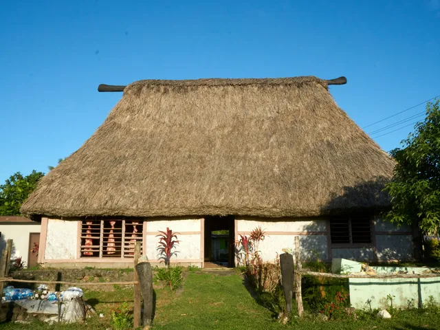 Traditional Fijian bure with a thatched roof in a village setting